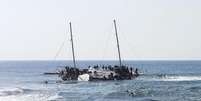 Imigrantes tentando chegar &agrave; Gr&eacute;cia num barco parcialmente naufragado perto da ilha de Rodes em abril. 20/04/2015  Foto: Michalis Loizos / Reuters