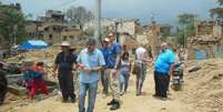 Sílvio Aparecido da Silva (de camisa quadriculada) caminha entre escombros do primeiro terremoto  Foto: Sílvio da Silva / Arquivo Pessoal