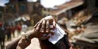 Mulher ferida em terremoto no dia 12 de maio caminha para hospital em Sankhu, no Nepal  Foto: Navesh Chitrakar / Reuters