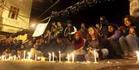 Estudantes acendem velas em homenagem aos dois mortos   Foto: Rodrigo Garrido / Reuters