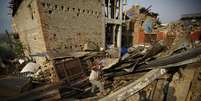 Homem caminha sobre destro&ccedil;os de casas destru&iacute;das por terremoto em 25/04 em Bhaktapur, no Nepal. 25/05/2015  Foto: Navesh Chitrakar / Reuters