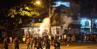 Policiais e manifestantes entram em confronto durante protesto contra a desocupação e demolição de imóveis no local conhecido como Favela do Metrô-Mangueira, na zona norte do Rio  Foto: Fernando Frazão / Agência Brasil