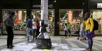 Pessoas olhando ofertas de emprego coladas em um poste no centro de São Paulo  Foto: Paulo Whitaker / Reuters