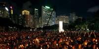 Pessoas seguram velas na pra&ccedil;a de Victoria  Foto: Bobby Yip / Reuters