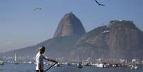 Homem com latrina na Baía de Guanabara durante protesto no Rio de Janeiro.  6/6/2015.  Foto: Sergio Moraes / Reuters