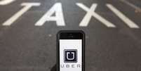 Foto ilustração do logotipo do Uber diante de uma faixa reservada para táxis, em Madri. 10/12/2014  Foto: Sergio Perez / Reuters