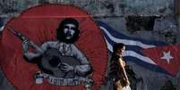 Grafite com imagem do herói revolucionário Ernesto "Che" Guevara e uma bandeira cubana, em Havana, Cuba, em maio  Foto: Enrique de la Osa / Reuters