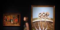 Funcion&aacute;ria da  Christie's entre os quadros "Two Men Working in a Field", de Francis Bacon, e "The Wedding Feast", de Pieter Brueghel,  em Londres.   12/06/2015  Foto: Stefan Wermuth / Reuters
