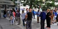 Gregos fazem fila para retirar dinheiro em caixas eletrônicos  Foto: Getty Images/ AFP