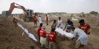 Volunt&aacute;rios enterram os corpos de pessoas que morreram devido a uma onda de calor intenso em um cemit&eacute;rio em Karachi, Paquist&atilde;o  Foto: Reuters
