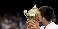 Djokovic beija o troféu de Wimbledon após conquistar o tricampeonato; liderança do ranking da ATP assegurada  Foto: Andy Rain / EFE