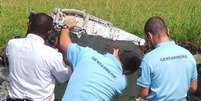 Policiais da ilha Reunião examinam o fragmento da asa do Boeing 777.  Foto: EPA