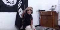 A roupa do menino é semelhante às usadas por Mohammed Emwazi, responsável pela morte do jornalista americano James Foley  Foto: YouTube/Reprodução
