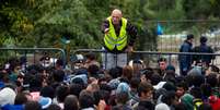 Voluntário dá instruções a migrantes que esperam para cruzar a fronteira entre a Croácia e Sérvia.  Foto: Getty Images