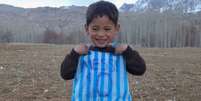 No Afeganistão, pequeno Murtazam, de apenas cinco anos, não se cansa de jogar futebol e falar para os amigos que é 'Meshi'  Foto: Lance!