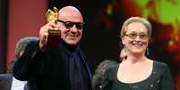 Gianfranco Rosi, vencedor do Urso de Ouro, recebe o pr&ecirc;mio das m&atilde;os de Meryl Streep  Foto: Getty Images