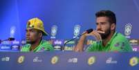 Douglas Costa (E), jogador da Seleção Brasileira de futebol, e o goleiro Alisson durante entrevista coletiva antes do treino na Granja Comary, em Teresópolis (RJ)  Foto: Gazeta Press