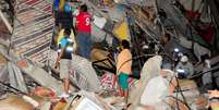 Grupo de pessoas busca sobreviventes nos escombros de um edifício em Manta, Equador.   Foto: Reuters