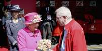 Rainha Elizabeth II atende ao mais antigo carteiro da Grã-Bretanha, Bob Hartley, em visita aos correios durante as comemorações de seu 90° aniversário.  Foto: Chris Jackson / Reuters