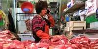 Venda de carne em um mercado em Pequim  Foto: EPA / BBC News Brasil