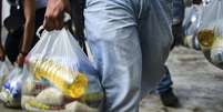 Pessoas ficam de olho nas sacolas levadas pela rua para saber onde achar certos produtos  Foto: Getty / BBC News Brasil