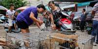 Cachorros são colocados à venda nas ruas da cidade para virarem comida no festival  Foto: EFE