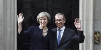 A nova primeira-ministra britânica, Theresa May, e seu marido Philip, saúdam os repórteres em sua chegada à residência oficial, no número 10 da Downing Street.  Foto: EFE