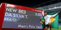 Thiago Braz posa ao lado do placar com seu recorde olímpico de 6,03m  Foto: Getty Images