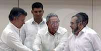    O  presidente Juan  Manuel  Santos e o líder  das  Farc, Timoleón  Jiménez,  durante  a negociação do acordo em    Havana. Ao centro, o presidente cubano, Raúl Castro   Foto: Agência Brasil