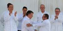 O presidente da Colômbia, Juan Manuel Santos, e o líder máximo das Farc, Rodrigo Londoño Echeverri, se cumprimentam após assinarem o acordo de paz  Foto: EFE