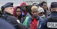 Imigrantes aguardam em longas filas pela remoção do campo de Calais  Foto: EFE
