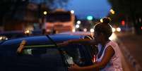 Venezuelana limpa para-brisa de carro na esquina da rua Mario Homem de Melo com a avenida Venezuela  Foto: EFE