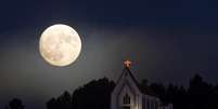 Superlua é vista por trás da igreja de Nossa Senhora da Conceição no norte de Portugal  Foto: EFE