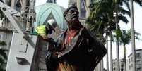 Estátua do apóstolo Paulo, na Praça da Sé, manchada com tinta vermelha, em protesto aos grafites apagados  Foto: Agência Brasil