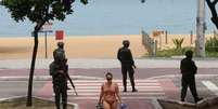 Mulher deixa a praia no litoral de Vitória cuja a segurança é feita por homens do Exército.  Foto: Reuters