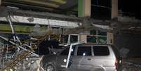 Carro é atingido por escombros de prédio durante terremoto no sul das Filipinas.  Foto: Reuters