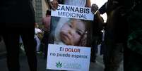 Mulher segura cartaz pedindo a legalização do uso medicinal da maconha na Argentina  Foto: Reuters