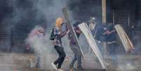 Manifestantes em Caracas, na Venezuela, entram em confronto com a Guarda Nacional do país, durante um protesto que pede a eleições no país e a saída de   Foto: Agência Brasil