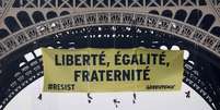 Ativistas do Greenpeace penduram faixa gigante na Torre Eiffel  Foto: Reuters