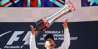 Lewis Hamilton levanta o trof&eacute;u de camp&atilde;o do GP da Espanha, em Barcelona.  Foto: Reuters