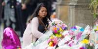 Mulher deposita flores em homenagem às vítimas do atentado após show de Ariana Grande em Manchester.  Foto: Reuters