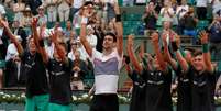 Djokovic saúda o público, junto com os gandulas da quadra, após vitória em Roland Garros  Foto: Reuters