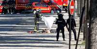 Bombeiros cobrem corpo de suspeito de ataque contra policiais em Paris  Foto: Reuters