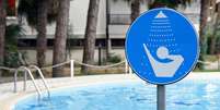 Aviso pedindo para tomar ducha antes de entrar na piscina  Foto: BBC News Brasil
