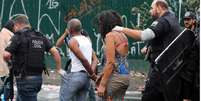Mulher conduzida por policial em ação na cracolândia  Foto: BBC News Brasil