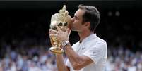 A cena se repete pela oitava vez: Federer beija o troféu de campeão de Wimbledon  Foto: Reuters
