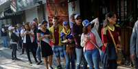 Venezuelanos encaram fila para votar no plebiscito informal sobre o governo de Maduro  Foto: Reuters