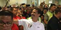 Hernanes faz selfie em sua chegada ao aeroporto de Cumbica em Guarulhos  Foto: Marcio Porto / LANCE!