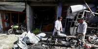 Vendedores recuperam pertences em frente  a loja após explosão de carro-bomba em Cabul  Foto: Reuters