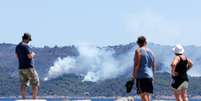 Turistas observam fumaça de incêndios florestais em La Croix-Valmer, na França  25/07/2017 REUTERS/Jean-Paul Pelissier  Foto: Reuters